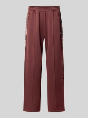 Trainingsbroek met Bies,
opgezet band en geborduurd logo Shop The Look MANNEQUINE