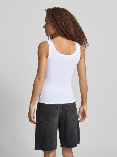 Młodzieżowy model nosi Slim Fit Tank Top aus Bio-Baumwoll-Mix Modell 'KITTE' von Pieces, biały, gładki, prążkowany materiał, szerokie ramiączka, widoczne detale, widok całej sylwetki z tyłu.