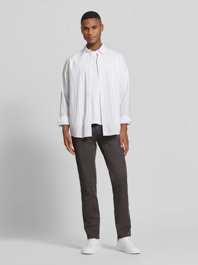Mannenmodel draagt Slim Fit Stoffhose met Lyocell-aandeel model 'Cadiz' van Brax in een 5-pocket ontwerp, katoenmix, bruine kleur, volledig lichaam vooraanzicht, context: elastische katoenmix met lyocell-aandeel, slim fit, knoop- en ritssluiting, taillewijdte 107 cm, binnenbeenlengte 81 cm bij maat 32/32.