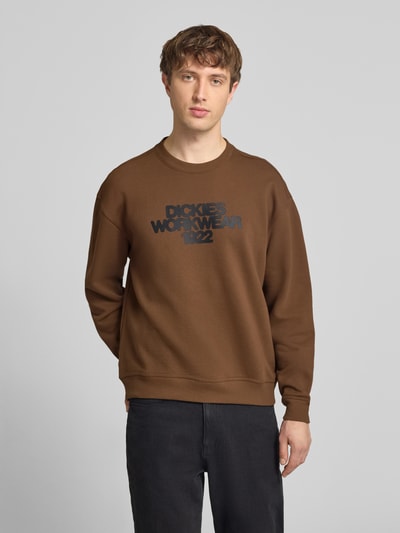 Männermodel trägt Sweatshirt mit Label-Print Modell 'TORREY' von DICKIES, Braun, Baumwoll-Mix, Lockerer-Schnitt, Rundhalsausschnitt, Gerippte-Abschlüsse, Ganzkörperansicht von vorne.