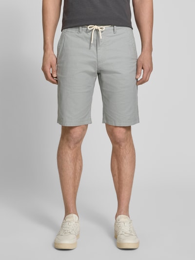 Männermodel trägt Regular Fit Chinoshorts aus Baumwoll-Mix Modell 'PHOENIX' von s.Oliver RED LABEL in Bi-Color Optik, 5-Pocket-Design, Tunnelzug, elastischer Bundabschluss, Ganzkörperansicht von vorne.