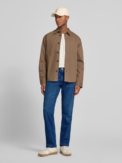 Männermodel trägt Straight Fit Jeans im 5-Pocket-Design Modell 'Greensboro' von Wrangler in Blau aus Baumwoll-Mix mit Stretch-Anteil, Gerader-Schnitt, Ganzkörperansicht von vorne.