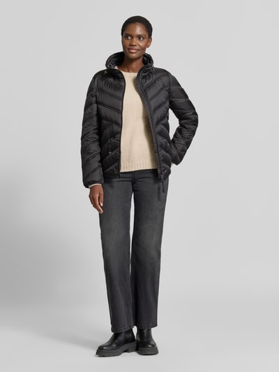 Vrouwenmodel draagt Steppjacke mit Stehkragen und Reißverschlusstaschen van Christian Berg Woman Selection in zwart, regular fit, ritssluiting, steekzakken met rits, schouderbreedte 42 cm, borstwijdte 51 cm, mouwlengte 58 cm, ruglengte 61 cm, vooraanzicht volledige lichaamsopname.