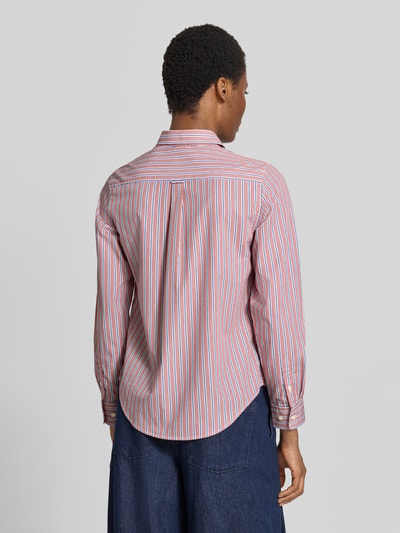 Frauenmodel trägt Regular Fit Langarmbluse aus reiner Baumwolle von GANT, rot-weiß-blau gestreift, glatte Textur, Ganzkörperansicht Rückansicht.