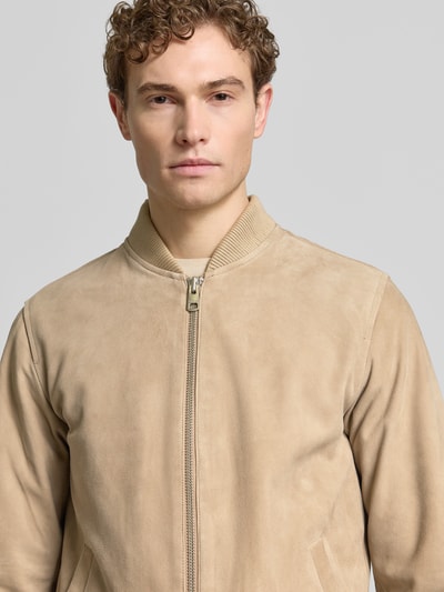 Männermodel trägt Regular Fit Wildlederjacken aus reinem Ziegenleder Modell 'ARCHIVE' von SELECTED HOMME in unifarbener Velourslederoptik, Nahaufnahme Oberkörper.