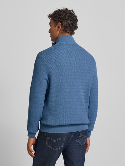 Männermodel trägt Strickpullover mit Stehkragen von Gant aus reiner Baumwolle, Regular-Fit, gerippte Abschlüsse, Rückenlänge 69 cm, Ganzkörperansicht Rückansicht.