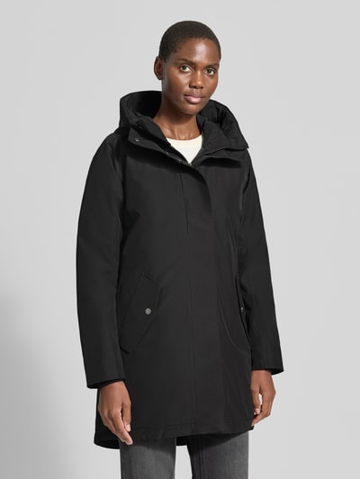 Vrouwenmodel draagt zwarte Regular fit parka met capuchon Model 'Alana' van Didriksons, steekzakken, ruglengte maat 36: 90 cm, schouderbreedte: 38 cm, borstwijdte: 48 cm, mouwlengte: 74 cm, volledig beeld van voren.