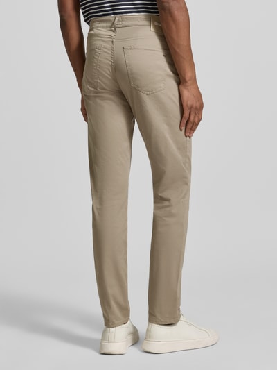 Męski model nosi Hose mit Eingrifftaschen Modell 'Chuck' von BRAX, mieszanka bawełny i lyocellu, krój slim fit, wpuszczane kieszenie, beżowe, widok na cały tył. Szerokość w rozmiarze 32/32: 43 cm, długość wewnętrzna nogawki: 81 cm.