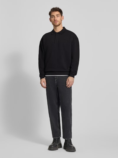 Männermodel trägt Oversized Sweatshirt mit Polokragen von CARLO COLUCCI in Schwarz, Baumwoll-Mix, Stitching, Ganzkörperansicht von vorne.