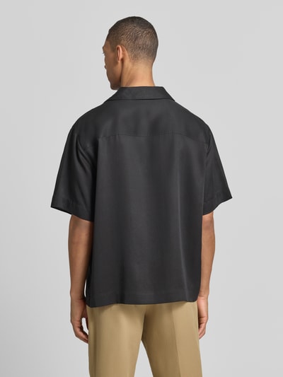 Männermodel trägt Relaxed Fit Freizeithemd aus reinem Lyocell Modell 'ESPINO' von HUGO in Schwarz mit Resortkragen, Rückansicht.