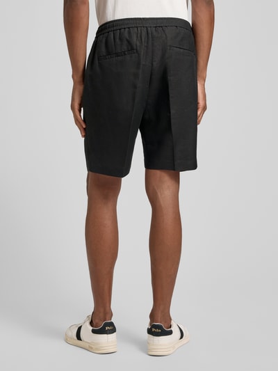 Männermodel trägt schwarze Shorts aus Leinen-Viskose-Mix Modell 'NEIL' von Antony Morato, Regular-Fit, Bügelfalten, elastischer Bund, Ganzkörperansicht Rückansicht. Herren Shorts, Bundweite bei Größe 50: 42 cm, Innenbeinlänge: 17 cm.