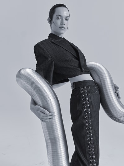 Frauenmodel trägt Jeans mit 5-Pocket-Design von ROTATE aus reiner Baumwolle, gerader Schnitt, Schnürverschluss, Nahaufnahme Oberkörper.
