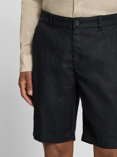 Męskimodel nosi Leinen Shorts mit Eingrifftaschen Modell 'PANDRUP' od Casual Friday, czarny len, krój straight fit, kieszenie boczne, szerokość w rozmiarze M: 44 cm, długość nogawki: 23 cm, zapięcie na guzik i zamek, widok przód, zbliżenie na górną część nóg.