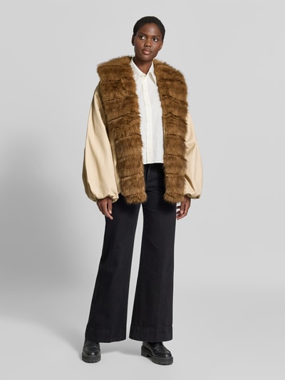 Frauenmodel trägt Jacke mit Kunstfellbesatz von ROTATE im Material-Mix mit Baumwoll-Anteil, taillierte Passform, Beige und Braun, Ganzkörperansicht von vorne.