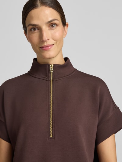 Frauenmodel trägt Sweatshirt mit Troyer-Kragen Modell 'Ritchie' von VARLEY in Braun, elastischer Viskose-Mix, kurzärmelig, Nahaufnahme Oberkörper.