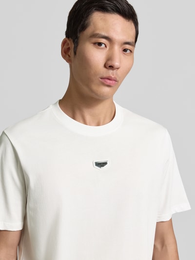 Mężczyzna nosi T-Shirt mit Label-Detail von Antony Morato, czysta bawełna, krój regular fit, białe, detal z logo, zbliżenie górnej części ciała.