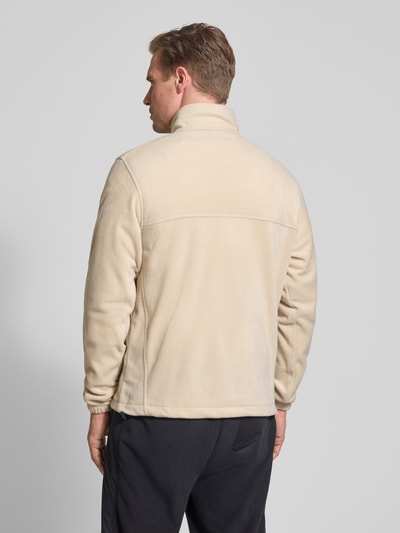 Männermodel trägt Regular Fit Fleecejacke mit Logo-Patch Modell 'Mountain' von Columbia in Beige, strukturierte Oberfläche, Ganzkörperansicht Rückansicht, Herren, Stehkragen, Reißverschluss, Eingrifftaschen, elastische Ärmelabschlüsse, Rückenlänge 70 cm, Ärmellänge 68 cm, Größe M.