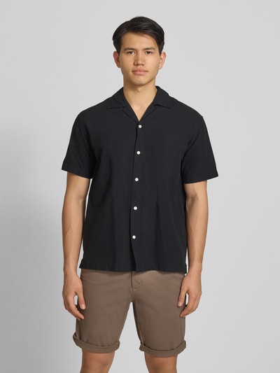 Mannenmodel draagt Regular Fit vrijetijdsoverhemd uit mix van katoen en linnen van Jack & Jones, zwart, met reverskraag en knoopsluiting, model 'BREEZE', ruglengte maat M 71 cm, schouderbreedte 50 cm, mouwlengte 26 cm, frontale volledige lichaamsweergave.