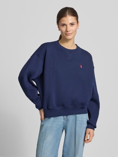 Vrouwenmodel draagt Oversized Sweatshirt aus Baumwoll-Mix van Polo Ralph Lauren in effen kleuren met logodetail, ronde hals, lange mouwen, geribde mouwboorden en rompzoom, materiaalverwerking: katoenmix, sweat. Ganzkörperansicht van voren.