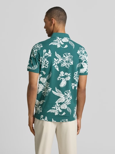 Männermodel trägt Modern Fit Poloshirt mit Label-Detail von Lerros, grün mit weißem Blumenmuster, reine Baumwolle, Ganzkörperansicht Rückansicht.