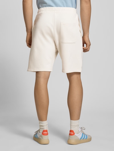 Männermodel trägt Regular Fit Shorts mit Label-Stitching von REVIEW aus Baumwoll-Mix, cremefarben, elastischer Bund, Ganzkörperansicht Rückansicht.
