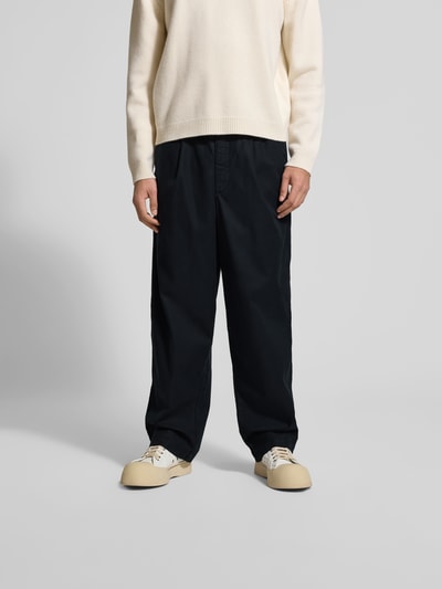 Männermodel trägt Loose Fit Stoffhose mit Lyocell-Anteil von Officine Générale in Schwarz, Baumwoll-Lyocell-Mix, Eingrifftaschen, Ganzkörperansicht von vorne.