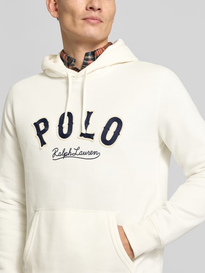 Männermodel trägt Hoodie mit Label-Stitching und Känguru-Tasche von Polo Ralph Lauren in Creme, Baumwoll-Mix, Nahaufnahme Oberkörper.