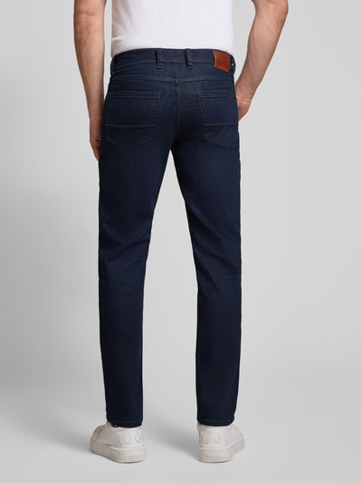 Męskimodel nosi Straight Fit Jeans aus Baumwoll-Mix von bugatti, granatowe, 5 kieszeni, zapięcie na guzik i zamek błyskawiczny, szerokość w rozmiarze 32/32: 43 cm, długość wewnętrzna nogawki: 80 cm, widok całej sylwetki z tyłu.