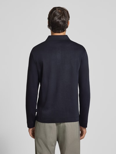Männermodel trägt Modern Fit Poloshirt aus reiner Baumwolle Modell '01Perolo' von JOOP! COLLECTION in dunkelblau mit glatter Textur, Ganzkörperansicht Rückansicht.