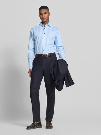 Männermodel trägt Regular Fit Business-Hemd mit Streifenmuster Modell 'Royal Kent' von OLYMP aus reiner Baumwolle, Ganzkörperansicht von vorne.