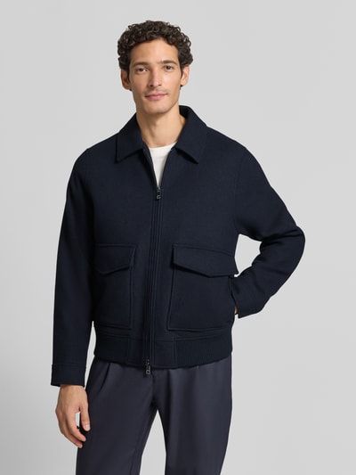 Männermodel trägt Bomberjacke mit Pattentaschen von ROY ROBSON, unifarben, Wollmix, Umlegekragen, Zweiwege-Reißverschluss, Ganzkörperansicht von vorne.