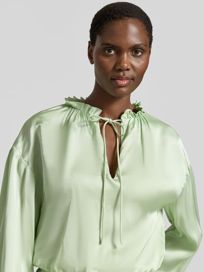 Frauenmodel trägt Regular Fit Langarmbluse aus reiner Viskose Modell 'BRISE' von BOSS Orange, Optik: Unifarben, Satin, Rüschenkragen, Label-Applikation, V-Ausschnitt, Nahaufnahme Oberkörper.
