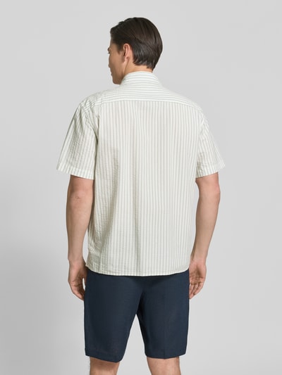 Männermodel trägt Relaxed Fit Freizeithemd aus reiner Baumwolle Modell 'STUART' von SELECTED HOMME mit gestreiftem Seersucker-Muster, Ganzkörperansicht Rückansicht.