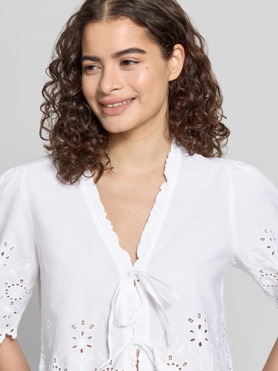 Frauenmodel trägt Regular Fit Bluse aus reiner Baumwolle Modell 'MIFFY' von Only, Optik: Unifarben, Rüschenkragen, Lochstickerei, Bindeschlaufe, Kurzarm, Materialverarbeitung: Popeline, Nahaufnahme Oberkörper.