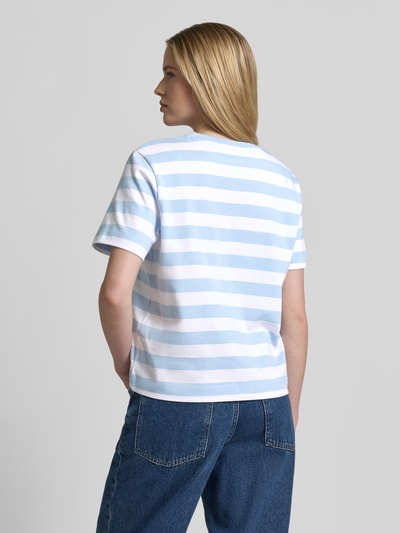 Modelka prezentuje damski t-shirt Boxy Fit T-Shirt aus reiner Baumwolle Modell 'ESSENTIAL' von Selected Femme, efekt: wzór w paski, naszywka z logo, okrągły dekolt, krótki rękaw, heavy jersey, 100% bawełna, widok całej sylwetki z tyłu.