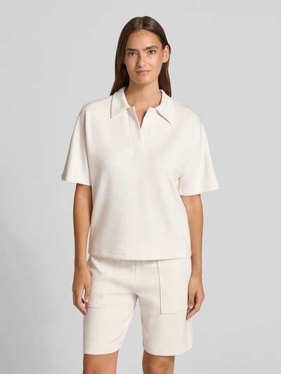 Kobiece modelka nosi Regular Fit Poloshirt mit V-Ausschnitt von Christian Berg Woman, mieszanka materiałów z domieszką modalu, krój regular fit, dekolt w serek, rękaw o dł. 1/2, jasny kolor, prosta faktura, widok całej sylwetki z przodu.