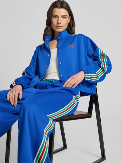 Frauenmodel trägt blaue Sweatjacke mit Kontraststreifen und Stitching, Stehkragen, Knopfleiste, Relaxed-Fit, Modell 'Brooklynn' von Lollys Laundry, Material-Mix mit Stretch-Anteil, Nahaufnahme Oberkörper.
