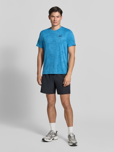 Männermodel trägt Regular Fit Sport-T-Shirt mit Strukturmuster Modell 'Pixelate' von Under Armour in Blau, Ganzkörperansicht von vorne.