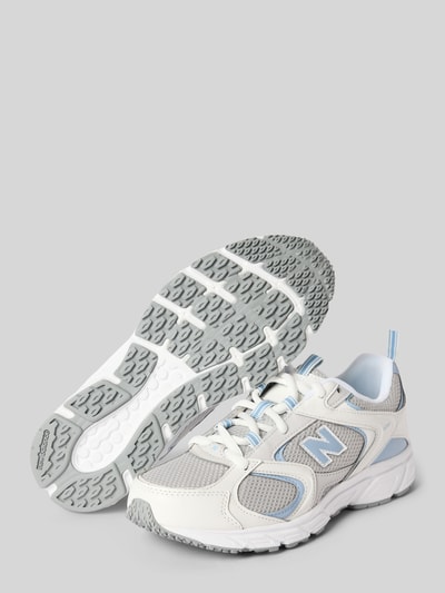 Produktfoto, Sneaker mit Kontrastbesatz von New Balance, abgerundete Form, graue strukturierte Sohle, Logo-Detail, weiße und blaue Farbakzente, Damen Sneaker, Schnürverschluss, Größe 40 mit 3 cm Absatzhöhe, 7 cm Schafthöhe, 9 cm Schaftweite