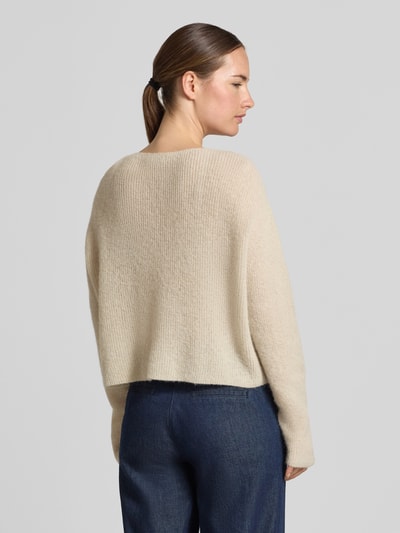 Frauenmodel trägt Strickpullover aus Alpaka-Mix Modell 'MENY' von DRYKORN in Beige, lockere Passform, Rückenansicht, Nahaufnahme Oberkörper.