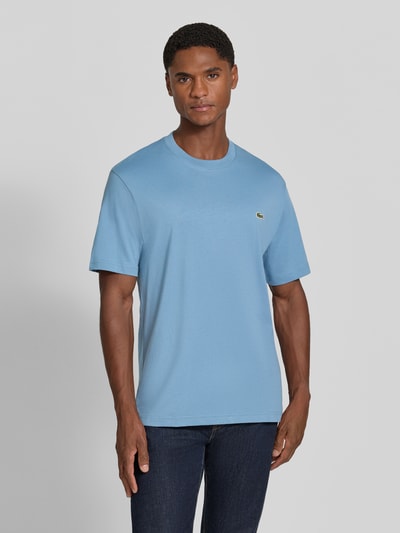 Männermodel trägt Regular Fit T-Shirt aus reiner Baumwolle von Lacoste in Hellblau, Herren T-Shirt, glatte Textur, Ganzkörperansicht von vorne.
