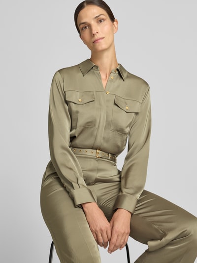 Frauenmodel trägt Jumpsuit mit Taillengürtel von MICHAEL Michael Kors in Satin mit Crinkle-Optik und goldenen Details, Nahaufnahme Oberkörper.