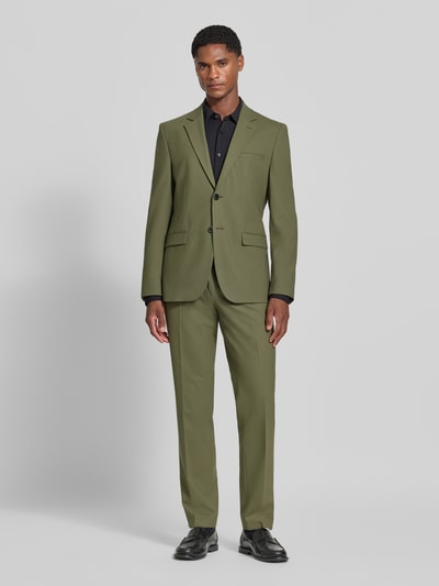 Männermodel trägt Super Slim Fit Sakko aus Woll-Mix Modell 'Arti 253X' von HUGO in Olivgrün, klassische Anzughose, Ganzkörperansicht von vorne.