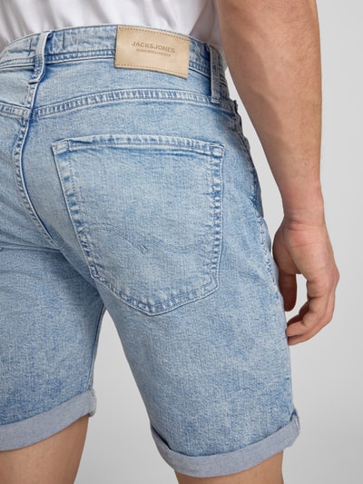 Männermodel trägt Regular Fit Jeansshorts mit Umschlag Modell 'RICK' von Jack & Jones aus Baumwoll-Elasthan-Mix, Detailaufnahme Rückansicht.