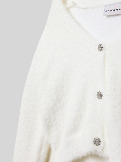 Produktfoto, Cropped Strickjacke mit Knopfleiste von DANAMADE, mieszanka materiałów, krój regular fit, krótki krój, prążkowane wykończenia, dekolt w serek, listwa guzikowa, biała faktura, miękka i puszysta powierzchnia.