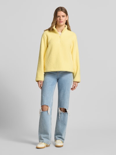 Vrouwenmodel draagt Regular fit pullover met opstaande kraag model 'Vera' van JJXX, teddystof, ritssluiting, gele kleur, volledige lichaamsvoorzijde.