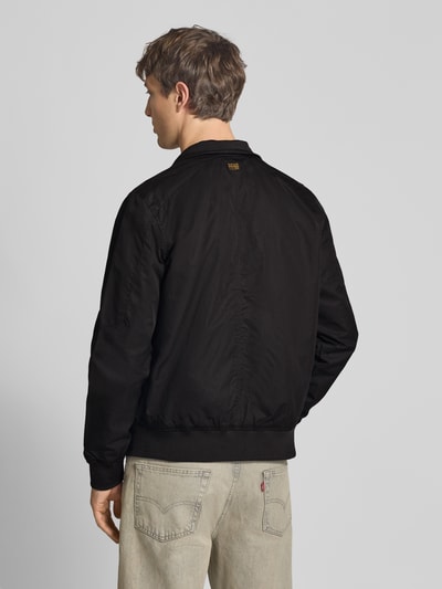 Männermodel trägt schwarze Jacke mit Stehkragen und Reißverschluss von G-Star Raw, Baumwoll-Mix, Regular Fit, Ganzkörperansicht Rückansicht.