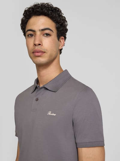 Männermodel trägt Slim Fit Poloshirt mit Label-Stitching von REVIEW aus reiner Baumwolle, Farbe Grau, Nahaufnahme Oberkörper.