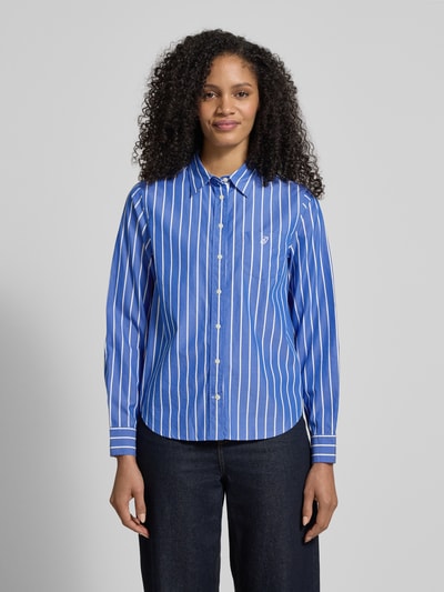 Męskimodel trägt Regular Fit Bluse mit Brusttasche und Label-Stitching von Gant w kolorze niebieskim z białymi paskami, z bawełny, kołnierzyk koszulowy, brustasza z wyhaftowanym logo, długość tyłu w rozmiarze 36: 65 cm, długość rękawów w rozmiarze 36: 61 cm, ganzkörperansicht von vorne.