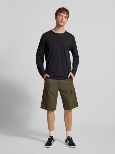 Männermodel trägt Shorts mit Cargotaschen von Carhartt Work In Progress in Olivgrün, Regular Fit, Ganzkörperansicht von vorne